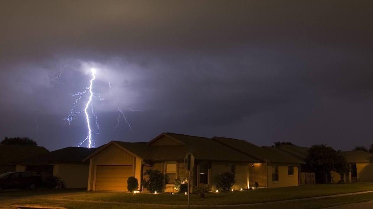 Lightning strikes in the night near residential area
